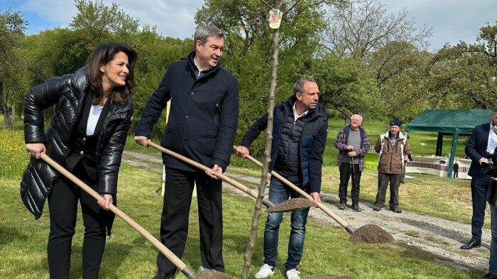 Ministerin Michaela Kaniber, Ministerpräsident Dr. Markus Söder und Minister Thorsten Glauber. Alles drei haben eine Schaufel in der Hand und pflanzen einen Obstbaum.