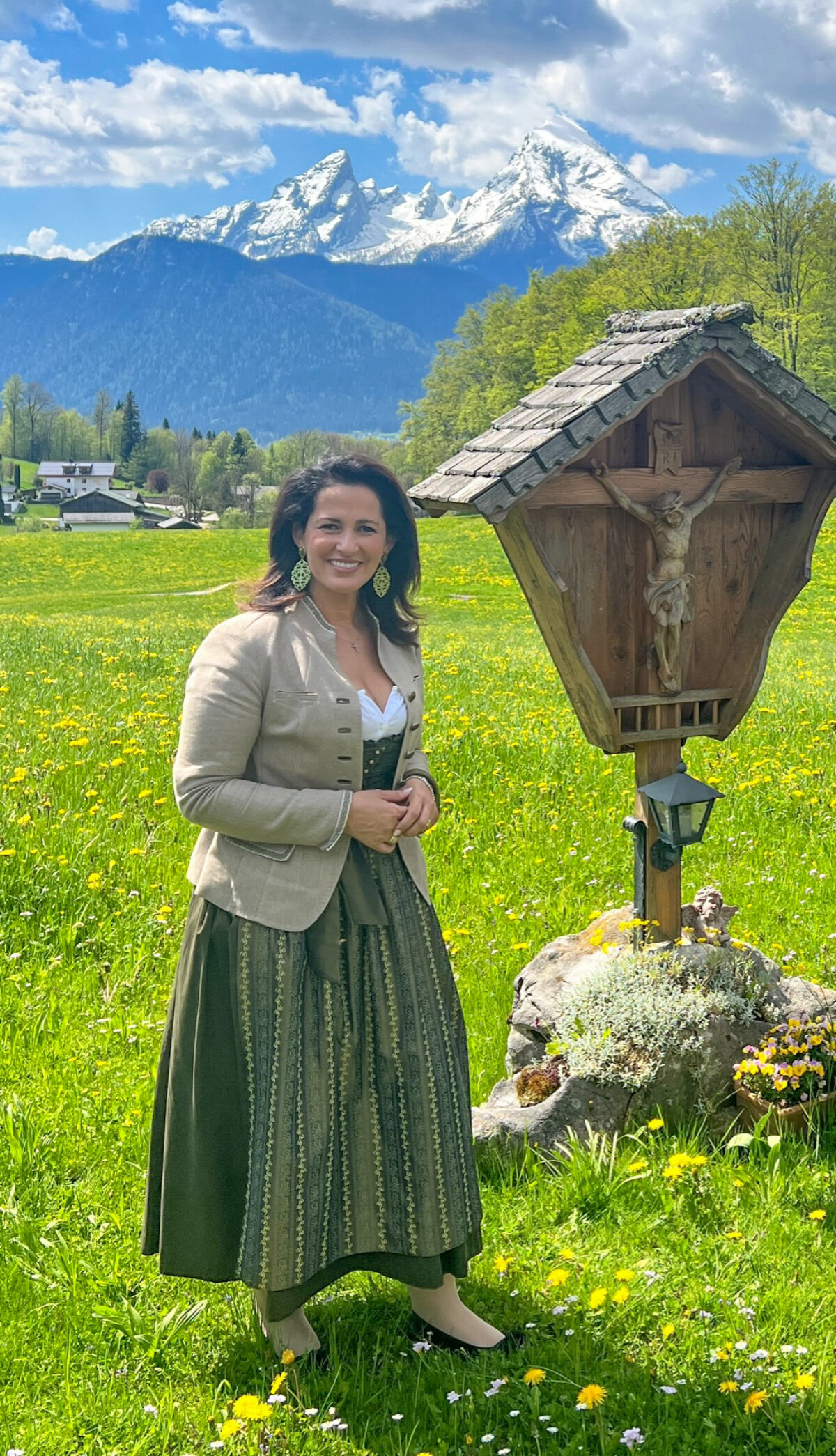 Ministerin Michaela Kaniber auf einer Wiese an einem Holzkreuz stehend.