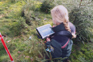 Förster bei der Verjüngungsinventur im Wald mit Laptop